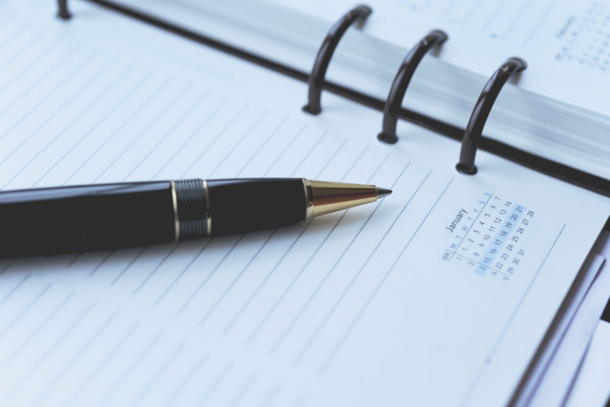 A black pen rests on a notebook, to indicate booking a CRPO-approved clinical supervision session