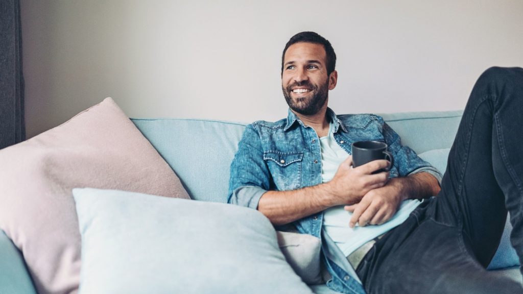 Man on couch feeling positive adaptive shifts after EMDR therapy session